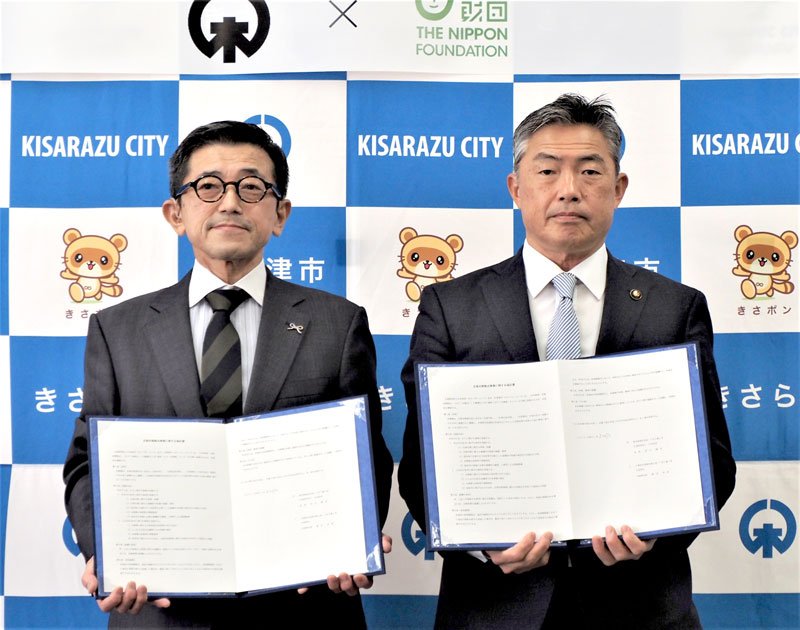 協定書を手にする前田専務理事（左）と渡辺市長＝木更津市
