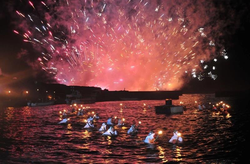 海女たちが松明を持って夜の海を泳ぐ「海女の大夜泳」（南房総市提供）
