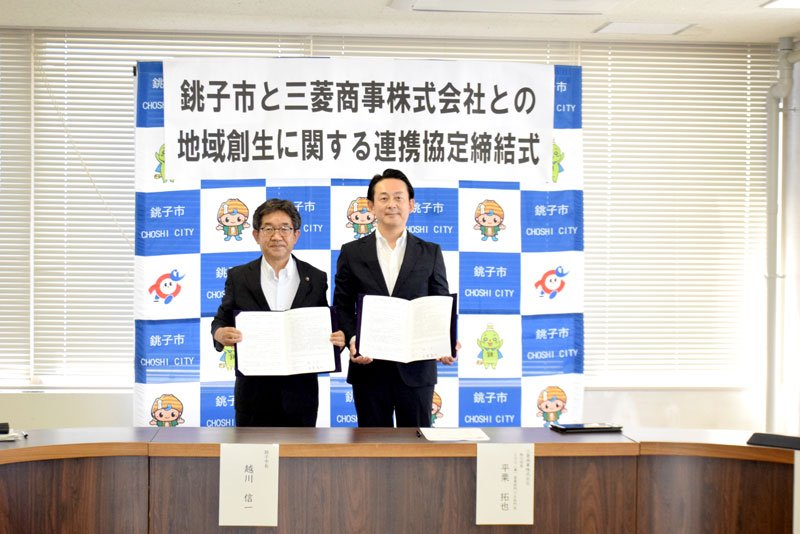 協定書を手にする越川市長（左）と三菱商事の平栗執行役員＝１３日、銚子市役所