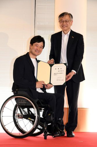 徳永学長から特任教授の委嘱状を渡された国枝さん（左）（麗澤大提供）
