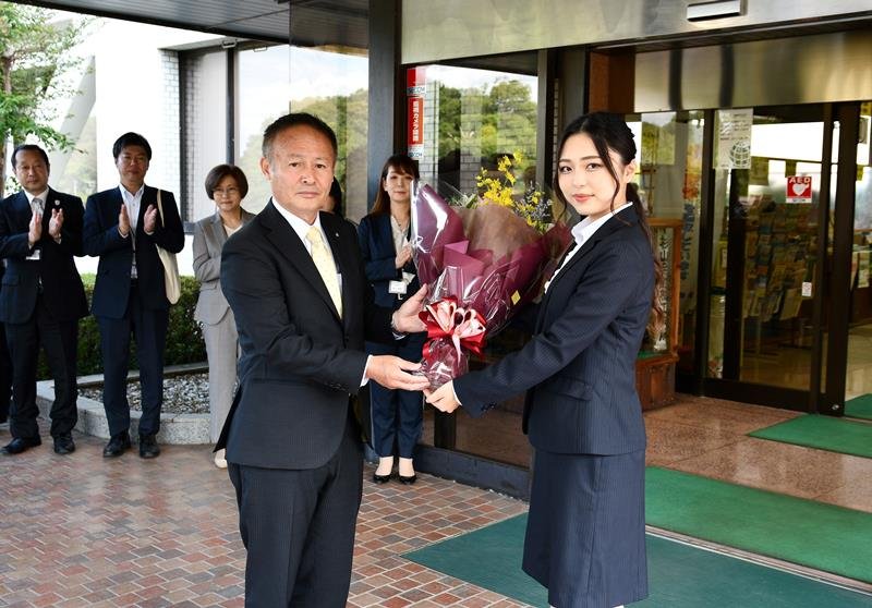 職員から花束を受け取る椿町長（左）＝２１日、神崎町役場