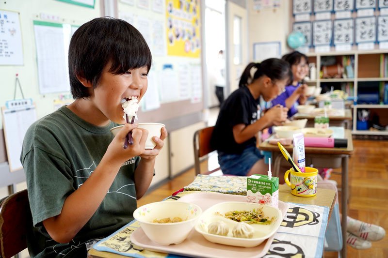給食で地元産有機米「いすみっこ」を食べる長者小５年生。校庭に作った田んぼで有機米を栽培する＝いすみ市
