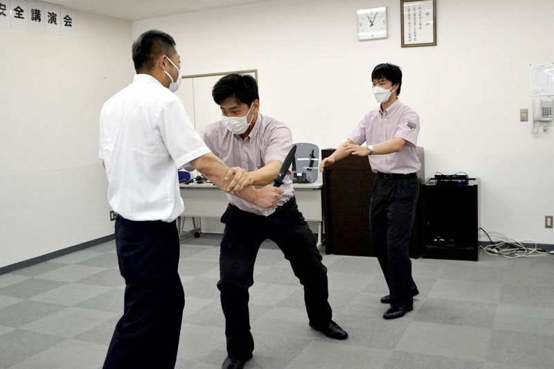 刃物を持った不審者への対応を確認する新京成社員（右と中央）