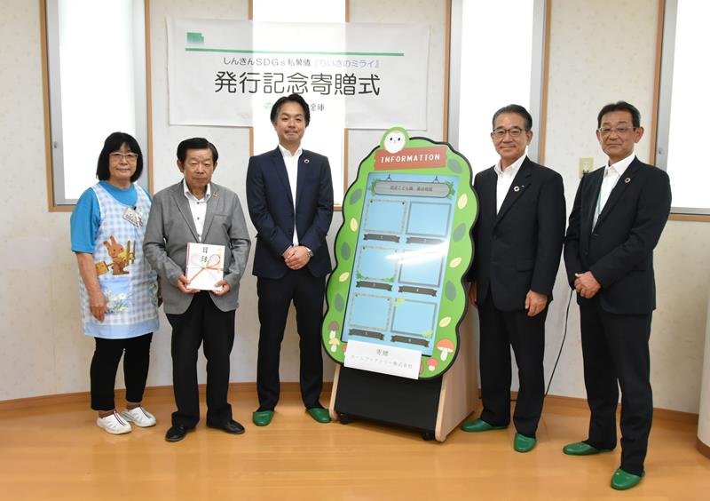電子掲示板を寄贈した菅沢社長（左から３人目）と目録を持つ石川理事長（同２人目）＝千葉市中央区
