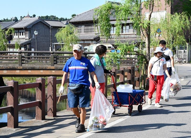 佐原の大祭夏祭りから一夜明け、ごみ拾いをする地元有志ら＝１７日、香取市
