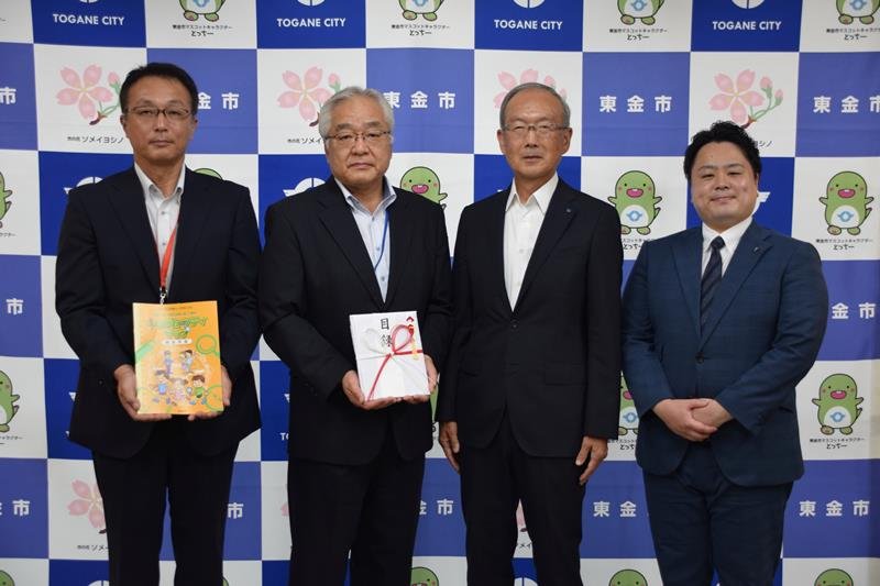 目録を持つ東金市の石川貢彦教育長（左から２人目）と、今井社長（同３人目）ら＝同市
