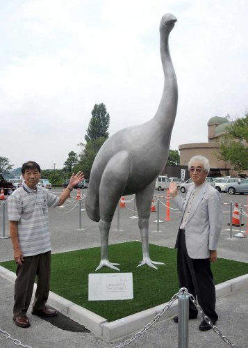 我孫子市鳥の博物館前の駐車場にお目見えしたジャイアントモアのモニュメントと、彫刻家の島田さん（左）、制作した市民団体の太田代表＝１９日
