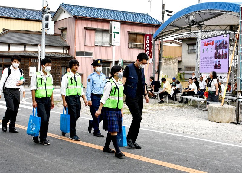 佐原の大祭の会場を署員と一緒に巡回する生徒ら＝香取市