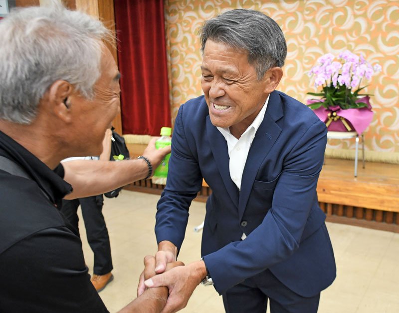 富里市長の再選を決め、支援者と握手して喜ぶ五十嵐氏（右）＝６日夜、同市
