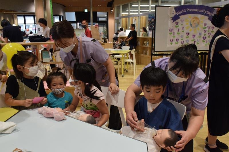 看護師らのアドバイスで赤ちゃん人形を抱く子どもたち＝旭市
