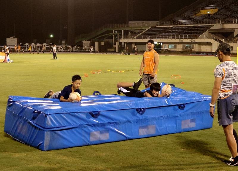 ラグビーのトライ練習でマットに飛び込む児童＝市原市のゼットエーオリプリスタジアム

