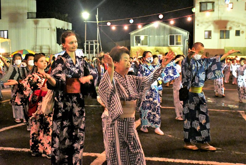 成田を表す曲に合わせて盆踊りをする成田山参道の人々や外国人の参加者＝成田市