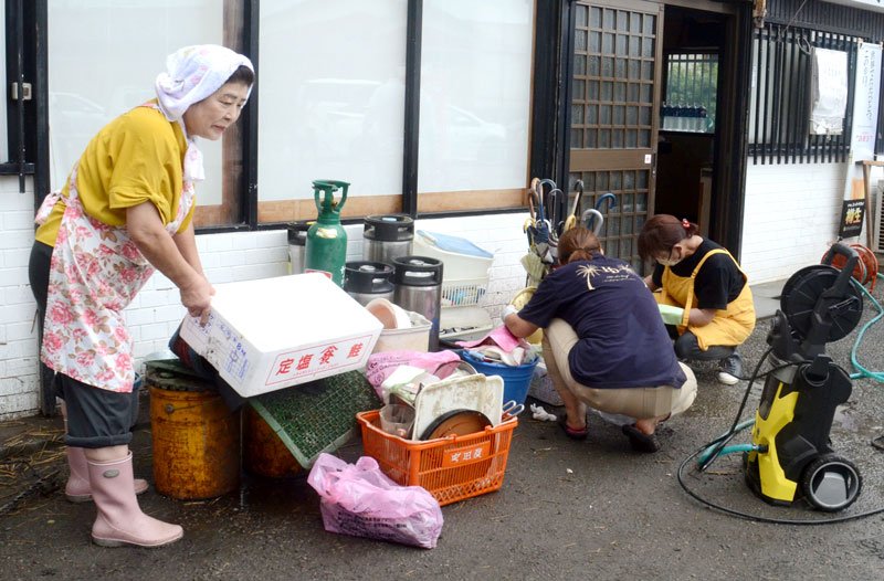浸水被害の後片付けを行うＪＲ大網駅近くの居酒屋の関係者ら＝９日午前１１時５０分ごろ、大網白里市駒込