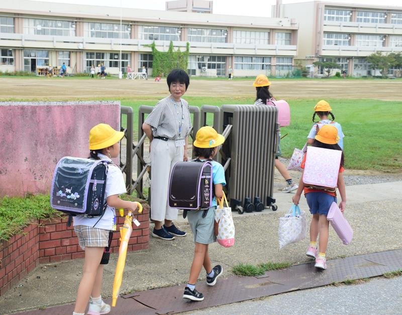 登校した児童を出迎える平野恭子校長＝１２日午前７時４５分ごろ、茂原市立中の島小
