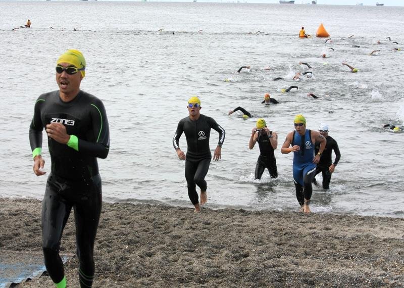 スイムを終え、いなげの浜に駆け上がる参加者＝２４日、千葉市美浜区
