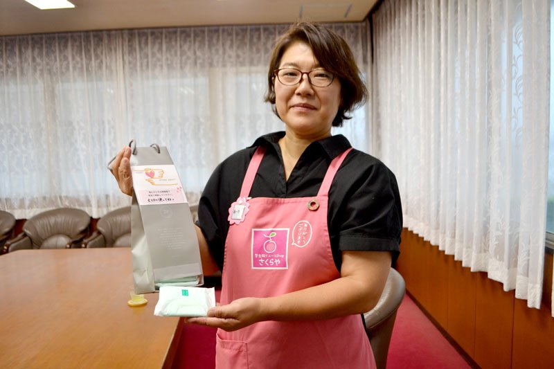 小学校トイレに設置する生理用品の袋を紹介する池上代表＝八千代市役所