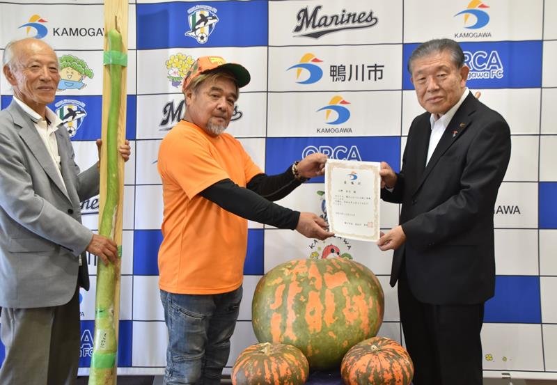 鴨川ふるさと大使の委嘱を受ける上野さん（中央）＝２０日、鴨川市役所
