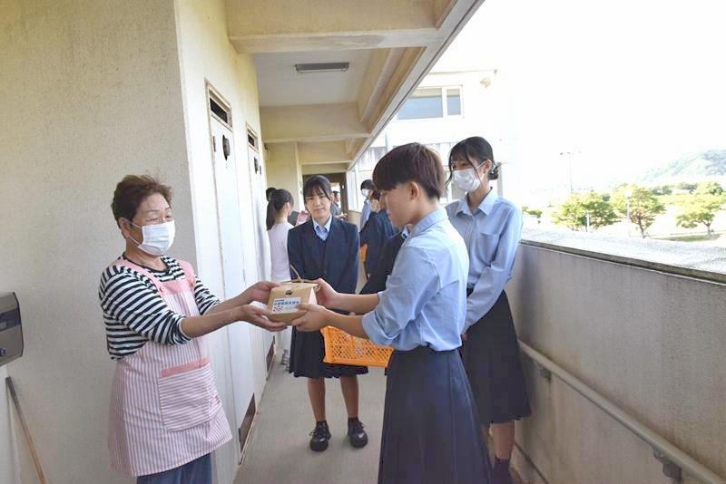 学校の田んぼで実った新米を渡す生徒たち＝２０日、旭市

