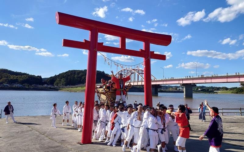 高瀧神社の秋季例大祭で高滝湖畔の鳥居をくぐる神輿＝市原市
