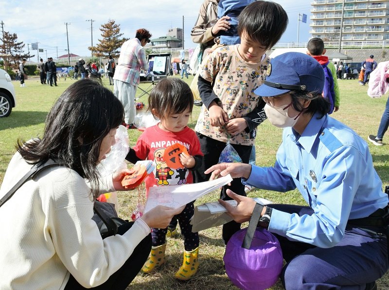 パンプキンをかたどった啓発グッズを渡し、還付金詐欺への注意を呼びかける署員＝２９日、白子町
