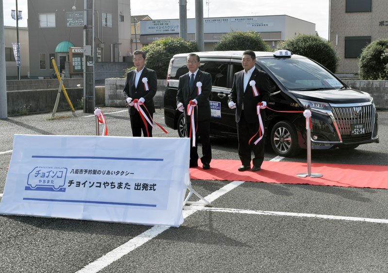 八街市予約型乗り合いタクシーの出発式でテープカットする北村市長（中央）ら＝２日、市役所駐車場
