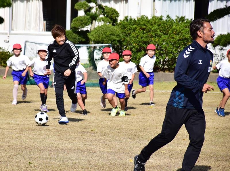 宮間さん（左）、佐藤さん（右）とボールを追いかける児童＝白子町立関小
