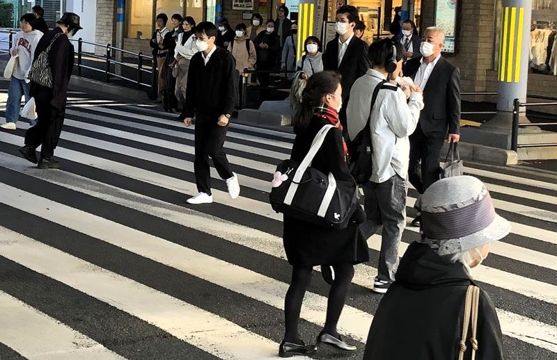 マフラーを巻いたり、厚手の上着を着たりして歩く人たち＝１３日、千葉市中央区

