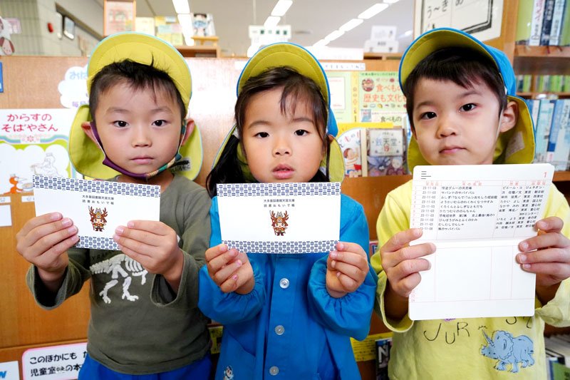 自分が借りた本の履歴が印字された「読書おもいで帳」を持つ保育園児＝大多喜町立図書館天賞文庫
