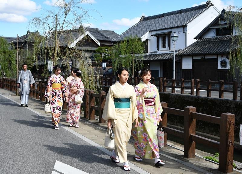 着物姿で佐原の町並みを散策する参加者ら＝１６日、香取市
