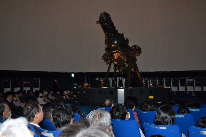 投映機「コスモくん」のお別れイベント「卒業式」で、特別上映プログラムに見入る観覧者ら＝１８日夜、船橋市プラネタリウム館

