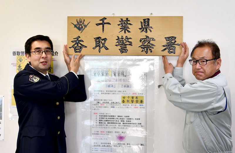 看板を制作した亀村社長（右）とデザインを手がけた高橋巡査部長＝香取署