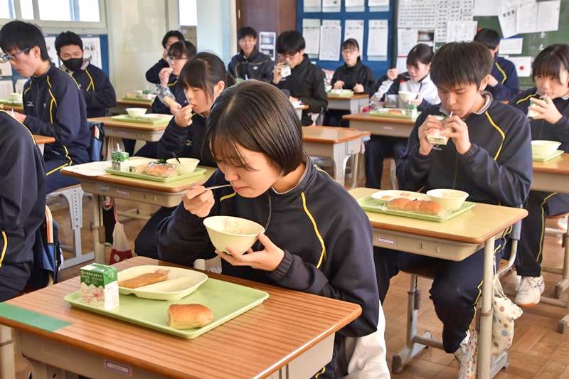 笹生さんが考案した「冬野菜のシチュー」を頬張る生徒＝７日、鴨川市
