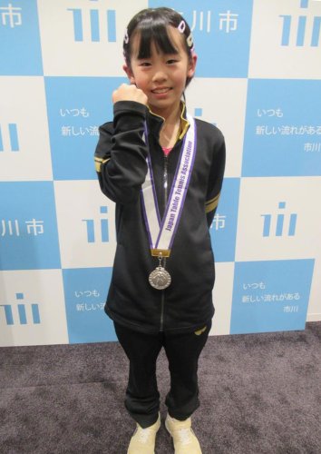 全日本卓球選手権で準優勝し、銀メダルを胸に拳を握る鈴木さん＝市川市役所