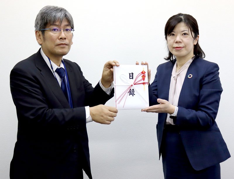 目録を手渡す小池委員長（右）