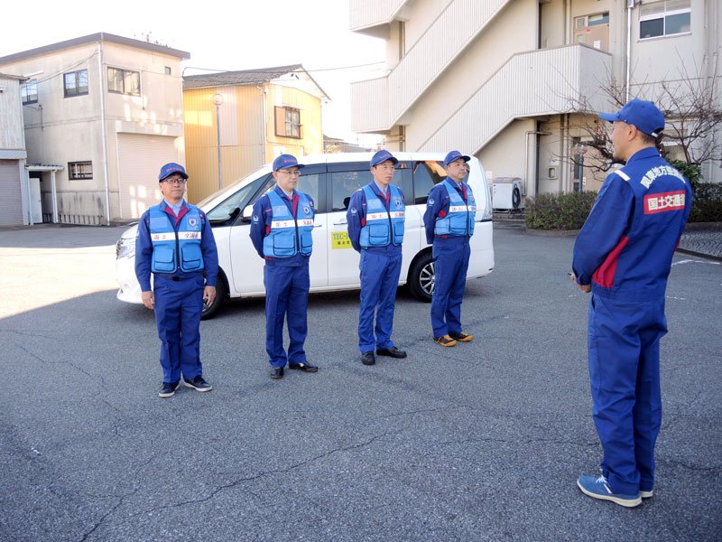 緊急災害対策派遣隊の出発式で田中所長（右）から激励を受ける隊員の４人＝８日、松戸市
