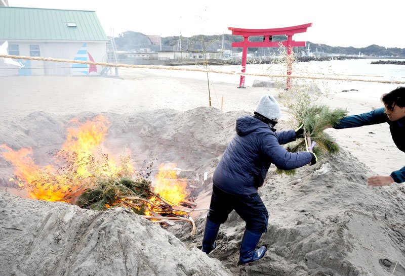 砂浜で正月飾りを燃やす「どんど焼き」＝１５日、勝浦中央海岸