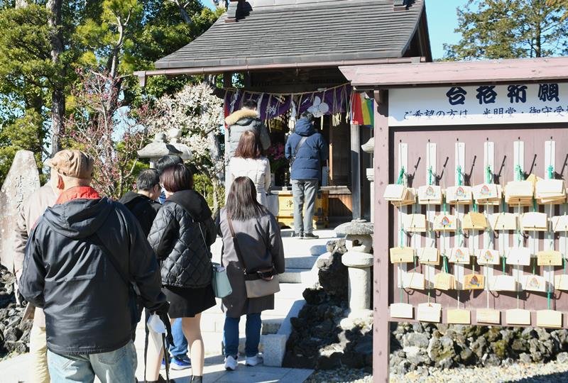 家族や自身の受験合格を祈り、特別開扉された天満宮で手を合わせる参拝客たち＝２４日、成田市の成田山新勝寺

