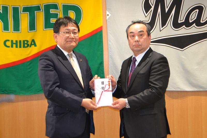 神谷市長（左）に目録を手渡す吉田理事長＝千葉市役所
