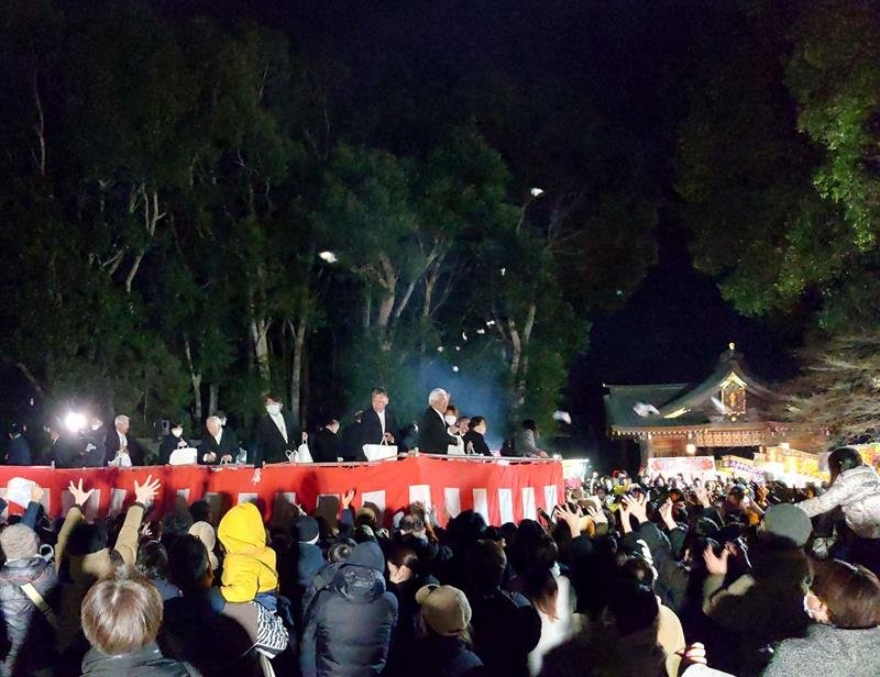 節分祭で宙を舞う小袋に手を伸ばす参拝客＝３日夜、市原市の姉埼神社
