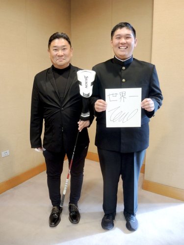 ３月の中学卒業と同時にゴルフのプロとなる香川友さん（右）。目標とする「世界一」の色紙を掲げた。愛用のドライバーを手にするのは父の正宏さん＝昨年１２月、野田市