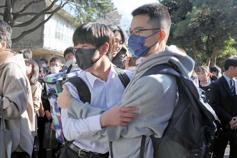 抱き合ってお互いの合格を喜ぶ受験生＝４日午前９時ごろ、千葉市中央区の県立千葉高校
