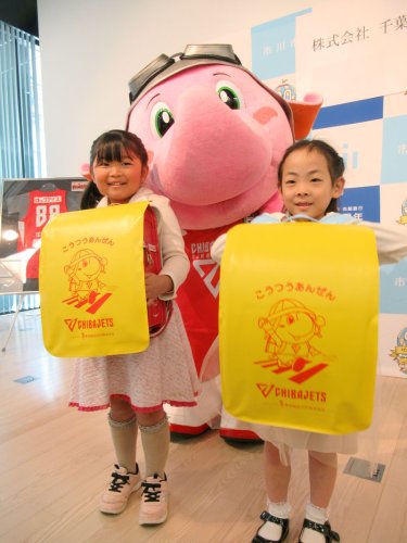 ジェッツのマスコット「ジャンボくん」が描かれたランドセルカバーを贈られた子どもたち＝市川市