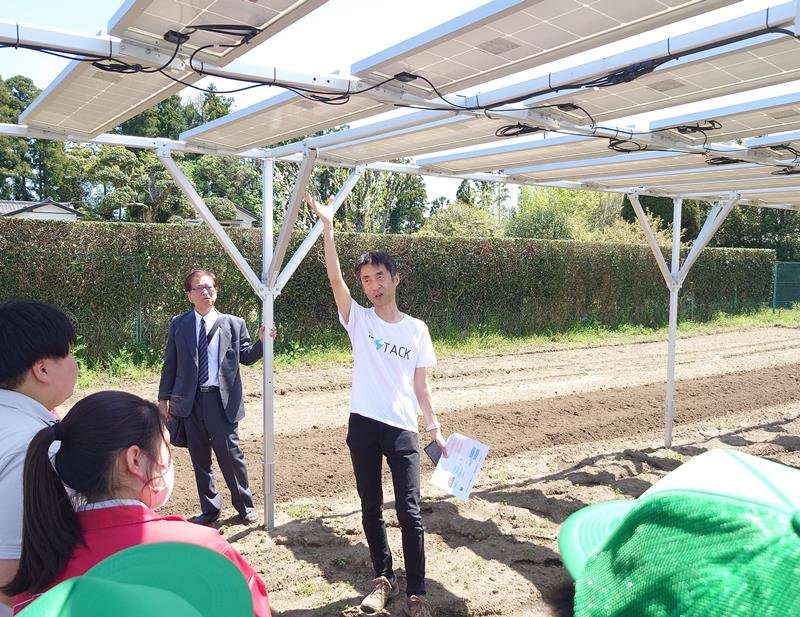 園芸科生徒に、ソーラーシェアリングの太陽光発電パネルを説明するロビーム社の担当者＝市原市の市原高校鶴舞グリーンキャンパス
