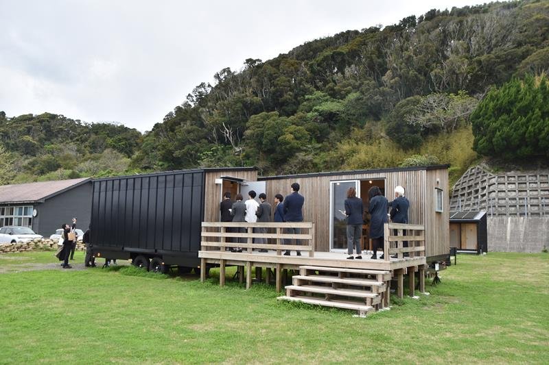 「インフラゼロでも暮らせる家」のプロトタイプ外観。壁・屋根一体型の太陽光パネルで効率的に電気を発電する

