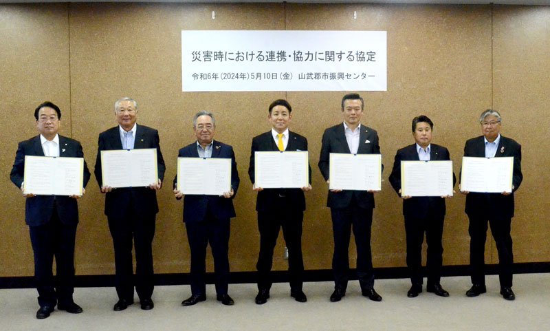 災害協定を締結した東金ＪＣの内山理事長（中央）と、横芝光町の佐藤町長（左から３人目）ら＝東金市