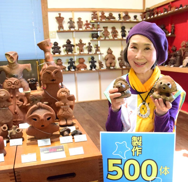 両手に５００体目の土偶（写真右）と約１５年半前に作った１体目の土偶を持つ田野さん＝大多喜町