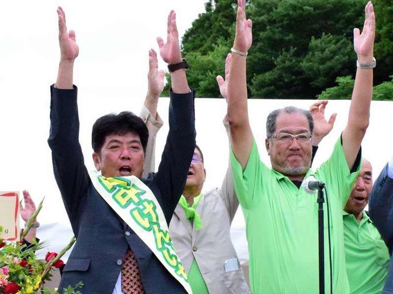 支援者と万歳して再選を喜ぶ田中氏（前列左）＝２５日午後６時ごろ、睦沢町上市場