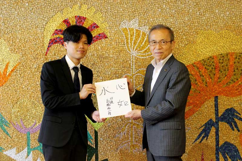 自身の抱負を記した色紙を松戸市長に手渡す高橋さん（左）＝５日、船橋市役所