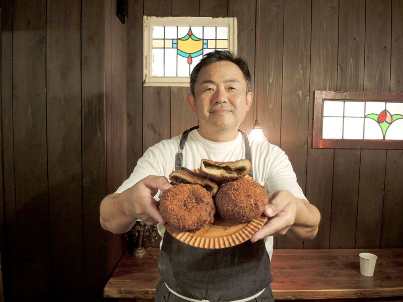 ザクザクした食感がたまらないカレーパンを手にする伊原さん＝松戸市