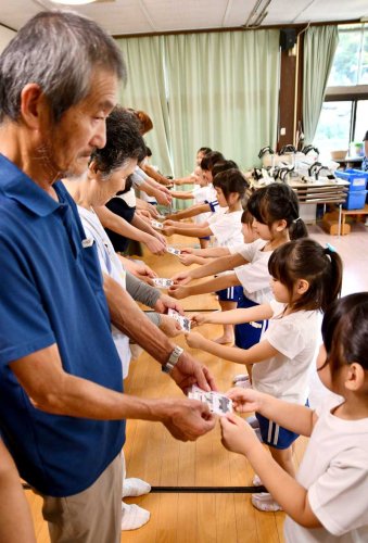 祖父母らに感謝の気持ちを込めたメッセージカードを手渡す園児＝１２日、香取市のまんまる保育園